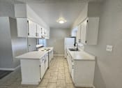 Thumbnail 18 of 27 - A kitchen with white cabinets and appliances.