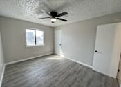 Thumbnail 22 of 27 - A room with a ceiling fan and a window.