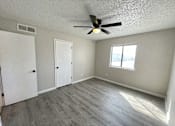 Thumbnail 26 of 27 - A room with a ceiling fan and a window.