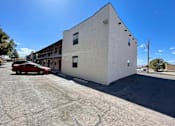 Thumbnail 27 of 27 - A red car is parked in front of a white building.