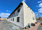 Thumbnail 2 of 27 - A white building with a blue sky in the background.