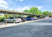 Thumbnail 28 of 28 - A parking lot with cars parked under a covered walkway.