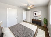 Thumbnail 7 of 28 - A bedroom with a bed, a bench, and a ceiling fan.