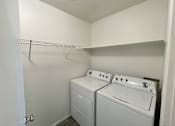 Thumbnail 13 of 28 - A small laundry room with a washer and dryer.
