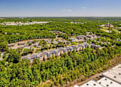 Thumbnail 19 of 19 - A bird's eye view of a residential area with apartment buildings surrounded by trees.