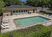Thumbnail 1 of 19 - A pool with a black fence and white chairs.