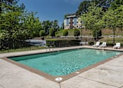 Thumbnail 2 of 19 - A small pool surrounded by a black fence and trees.