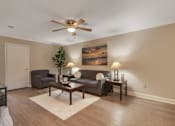 Thumbnail 7 of 19 - A living room with a ceiling fan, two couches, and a painting on the wall.
