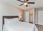 Thumbnail 13 of 19 - A bedroom with a large bed and a ceiling fan.
