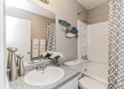 Thumbnail 14 of 19 - A bathroom with a white sink and a white toilet.