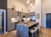 Thumbnail 2 of 21 - a kitchen with an island and a table with chairsat Sterling Nashville West Apartments, Nashville