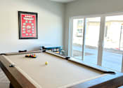 Thumbnail 23 of 35 - a pool table in a game room with a view of the patio