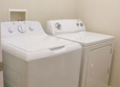 Thumbnail 4 of 18 - A white washing machine and dryer in a small room.
