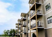 Thumbnail 15 of 18 - Apartment building with balconies and windows.