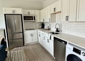Thumbnail 13 of 35 - a white kitchen with stainless steel appliances and white cabinets