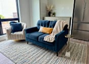 Thumbnail 15 of 35 - a living room with a blue couch and a chair with pillows