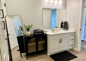 Thumbnail 21 of 35 - a bathroom with a vanity with a mirror and a sink
