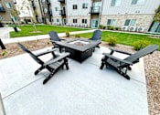 Thumbnail 17 of 35 - a patio with a fire pit and chairs