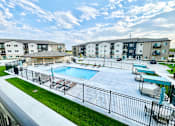 Thumbnail 12 of 35 - an outdoor swimming pool with apartments in the background