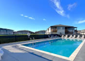 Thumbnail 16 of 16 - a swimming pool with chairs around it in front of a house