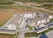 Thumbnail 35 of 35 - A large apartment complex with a parking lot in front.