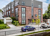 Thumbnail 2 of 35 - a brick building with a car parked in front of it