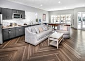 Thumbnail 21 of 35 - A modern living room with a grey couch and a wooden floor.