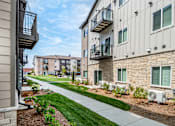 Thumbnail 29 of 35 - A row of apartment buildings with balconies and landscaping.