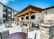 Thumbnail 15 of 35 - A patio with a table and chairs is surrounded by stone walls.