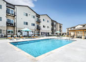 Thumbnail 13 of 35 - A swimming pool in front of apartment buildings.