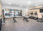 Thumbnail 26 of 35 - A gym with a variety of equipment including treadmills, weights, and exercise machines.