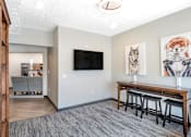 Thumbnail 20 of 35 - A living room with a grey carpet and a wooden bar.