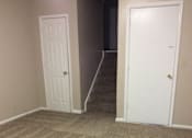 Thumbnail 14 of 15 - Family room in the Yeakel Townhome, featuring a carpeted floor and a wall.