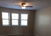 Thumbnail 2 of 15 - Living room in the Yeakel Townhome, featuring a carpeted floor and a window with blinds.