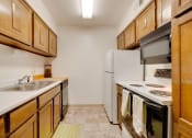 Thumbnail 32 of 35 - Kitchen in the one-bedroom model unit at Olde English Village, featuring spacious countertops and practical appliances.