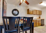 Thumbnail 33 of 35 - Dining area in the one-bedroom model unit at Olde English Village, with the kitchen visible in the background.