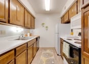 Thumbnail 23 of 35 - Kitchen in the two-bedroom model unit at Olde English Village, featuring spacious countertops and practical appliances.