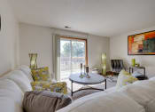 Thumbnail 16 of 35 - Spacious living room in the two-bedroom model unit at Olde English Village, with natural light and stylish furnishings.