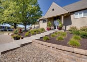 Thumbnail 3 of 35 - Exterior view of the clubhouse building at Olde English Village, surrounded by well-maintained landscaping and a welcoming atmosphere.