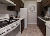 Thumbnail 15 of 17 - Cozy kitchen featuring wooden cabinetry, a stove, and ample counter space, perfect for home cooking.
