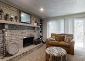 Thumbnail 13 of 17 - A cozy living room with a love seat, a fireplace, a floor clock, and a round coffee table, softly lit with warm lighting for a relaxing atmosphere.