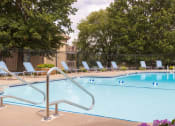 Thumbnail 10 of 17 - Wilshire swimming pool, surrounded by well-maintained landscaping and seating for residents to enjoy.