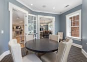 Thumbnail 21 of 32 - A dining room with a table and chairs.