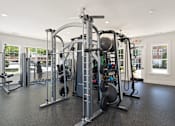 Thumbnail 22 of 32 - A gym with a variety of equipment including a leg press machine.