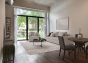 Thumbnail 24 of 28 - a living room with a couch and a table and a sliding glass door