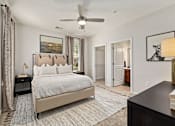 Thumbnail 7 of 32 - A bedroom with a large bed and a ceiling fan.