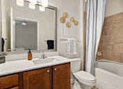 Thumbnail 10 of 32 - A bathroom with a sink, toilet, and bathtub.