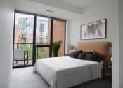 Thumbnail 27 of 28 - a bedroom with a bed and a sliding glass door to a balcony