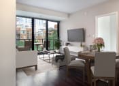 Thumbnail 26 of 28 - a living room and dining room with a table and chairs and a television