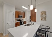 Thumbnail 3 of 43 - a kitchen with a large white counter top and a sink